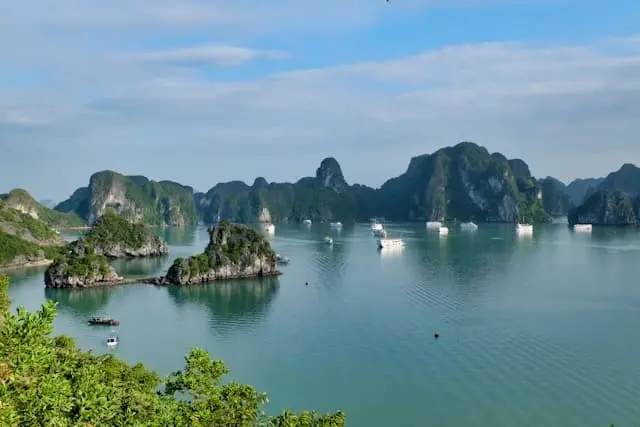 Cruise ships sailing between limestone islands of Halong Bay