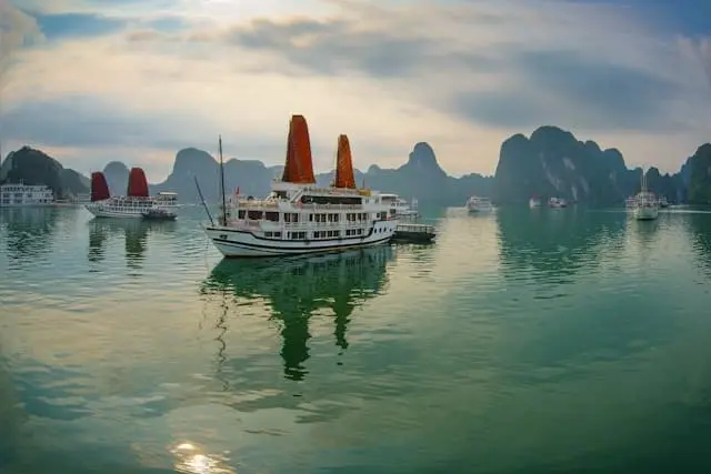 Traditional junk boats with orange sails anchored in Halong Bay