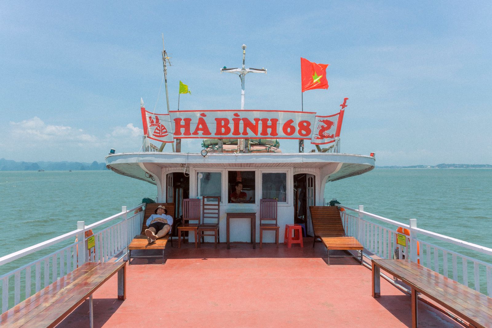 Tour boat under limestone cliffs in Halong Bay